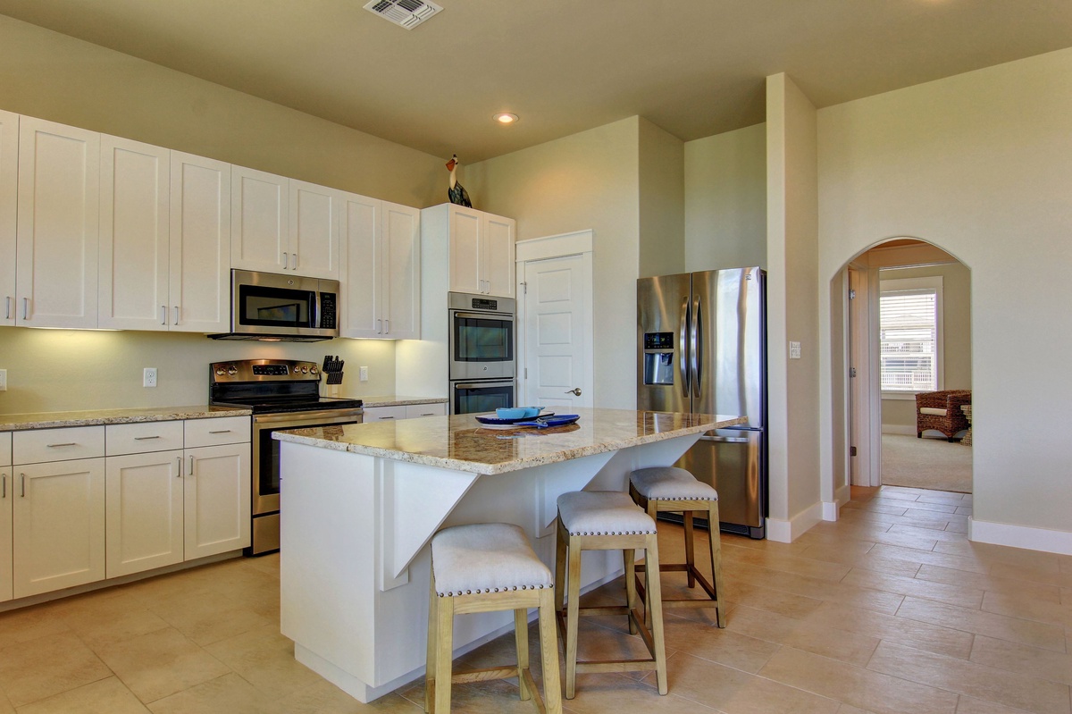 Cook your favorite meals in this bright, fully-equipped kitchen featuring granite countertops, stainless steel appliances, and a breakfast bar.