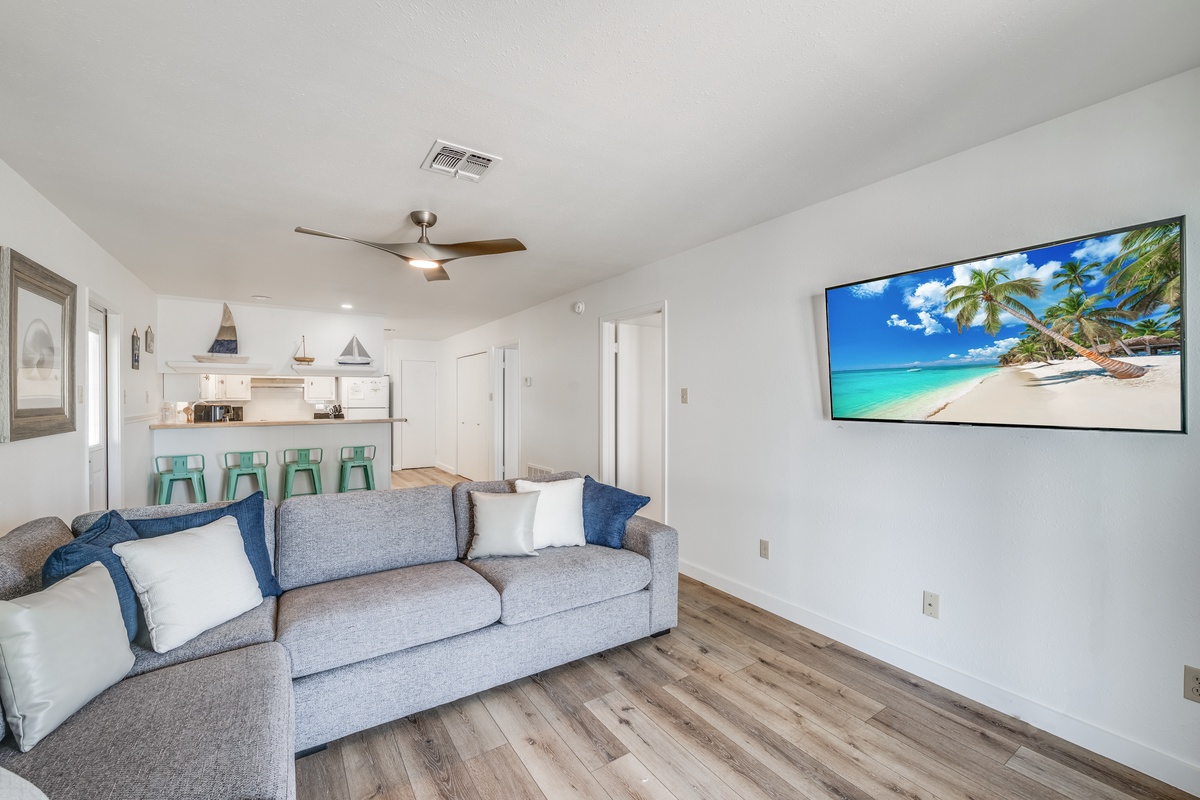 Relax in this bright, modern living space where coastal vibes meet comfort. Your sectional sofa invites movie nights under the ceiling fan's gentle breeze.