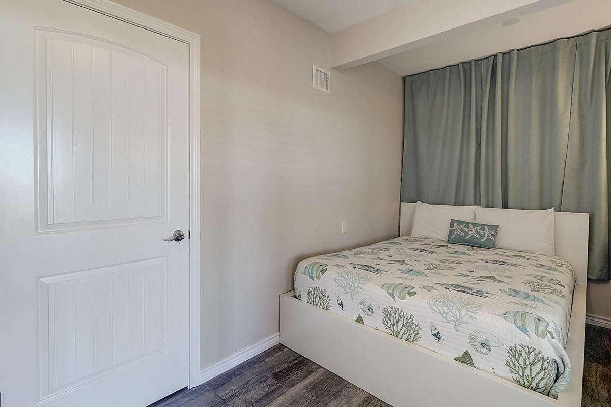 Drift off in your cozy bedroom, where ocean-themed linens and soft curtains create a peaceful retreat.