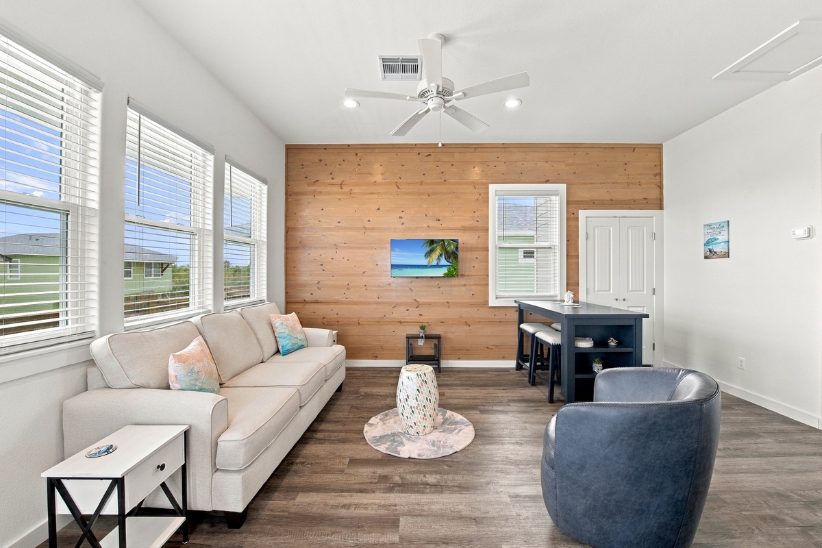 Settle into this sun-drenched living room with vaulted ceilings and warm wood accents. You'll find plenty of space to unwind on plush seating or gather at the kitchen bar after a day exploring.