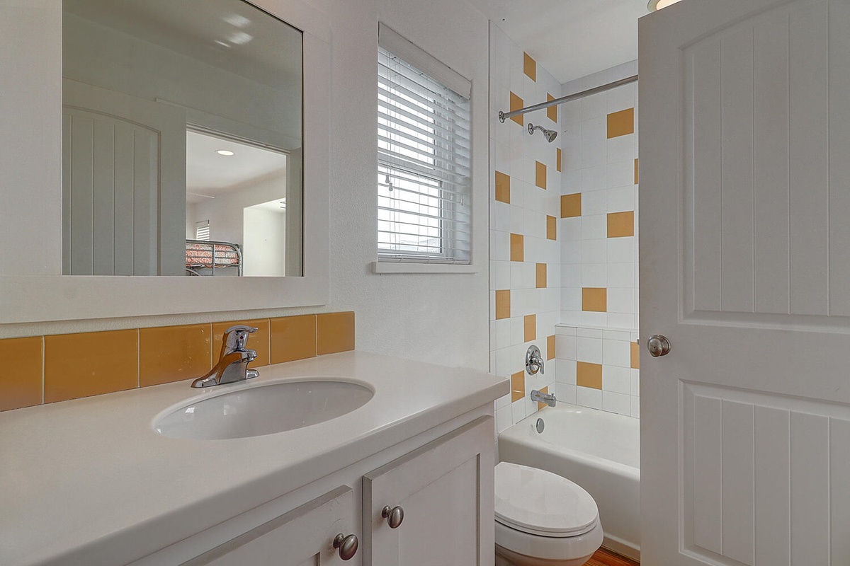 Your bright, cheerful bathroom features sunny orange accents and a relaxing tub-shower combo for unwinding after your adventures.
