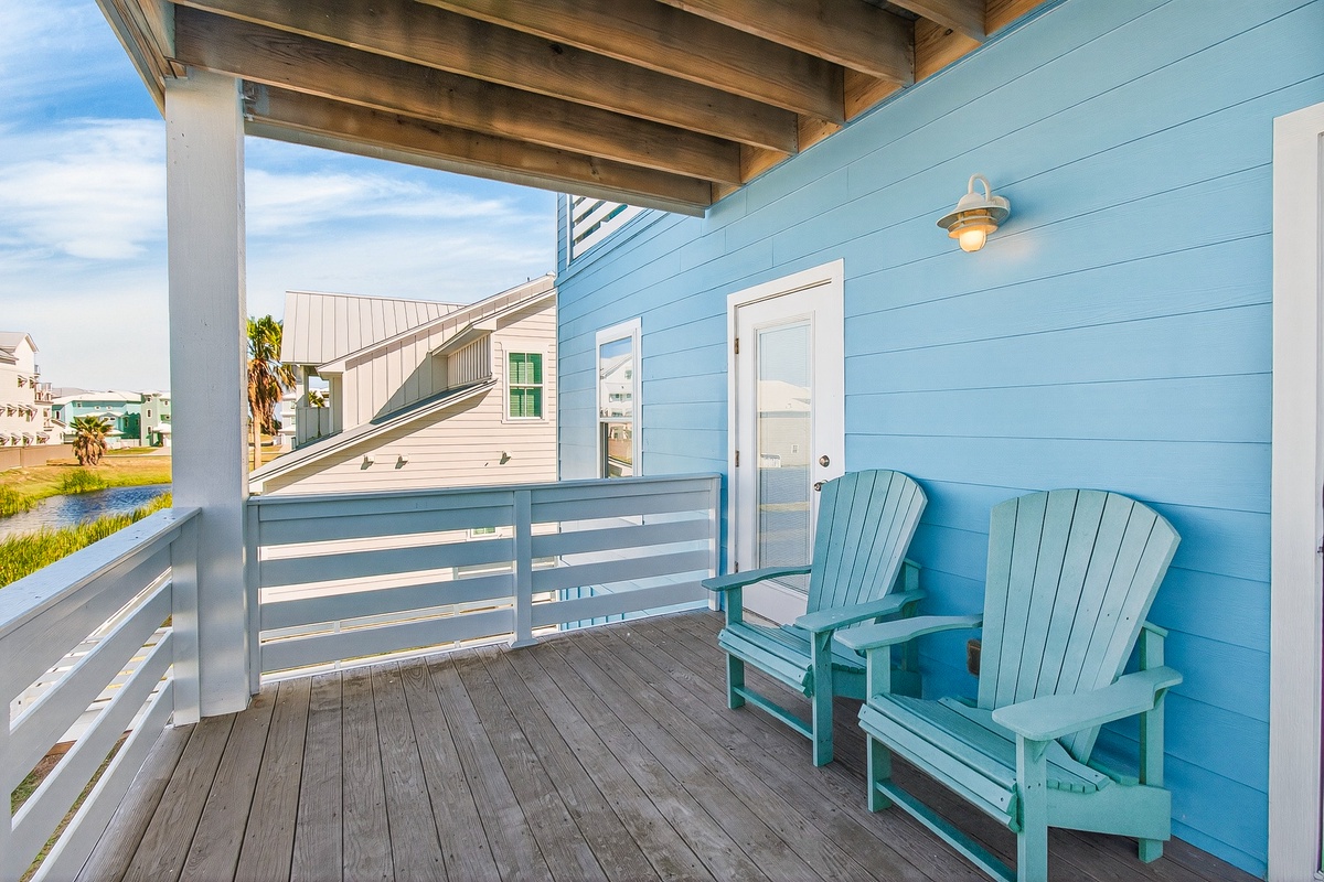 Settle into cozy turquoise chairs on your private covered balcony, perfect for morning coffee or evening relaxation.