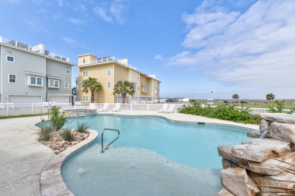 A refreshing pool surrounded by tropical landscaping offers the perfect spot to unwind after your beach adventures.
