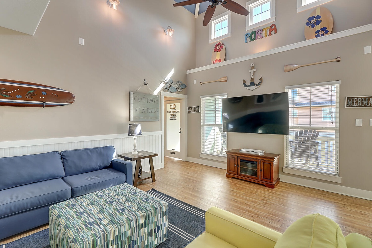 Relax in your coastal-themed living room with vaulted ceilings, comfortable seating, and charming nautical touches that make you feel like you're by the sea.