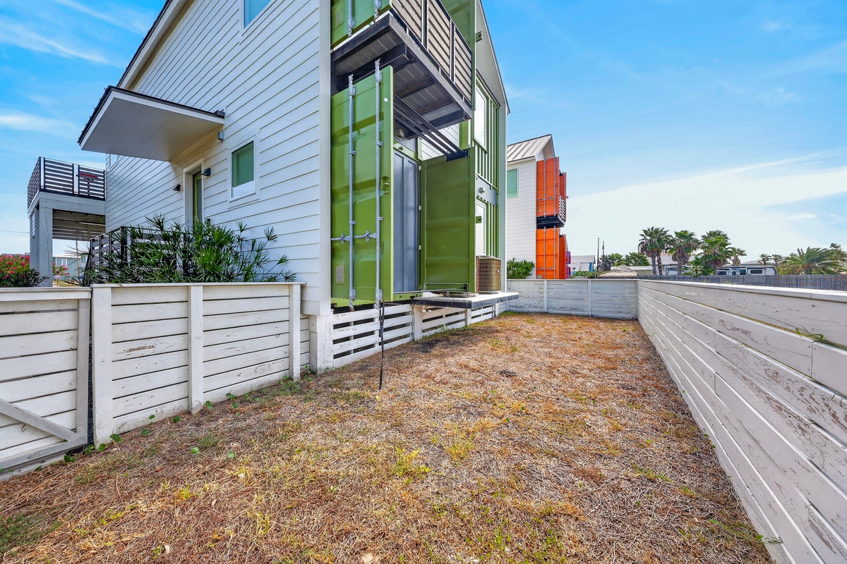 Modern coastal property featuring contemporary architecture with vibrant green and white accents, situated in a sunny beachside community just minutes from the shore.