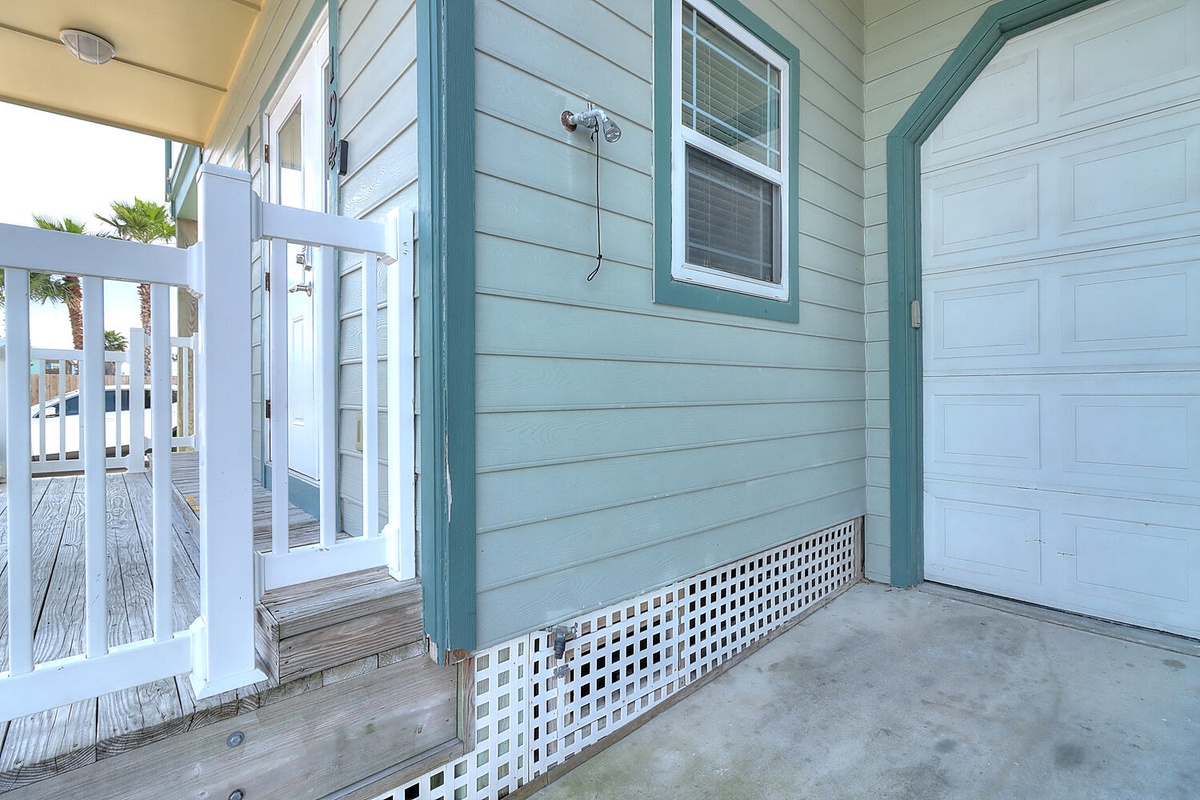 Charming coastal entrance with seafoam siding and white accents creates a welcoming arrival experience.