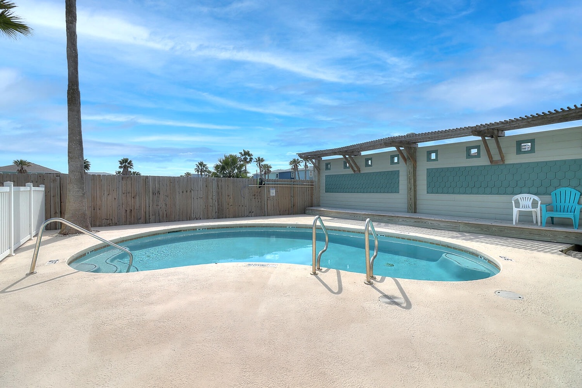 Dive into your private oasis with this sparkling pool surrounded by tropical palms and comfortable seating areas.