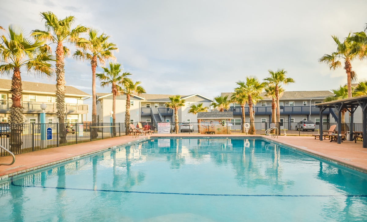 Crystal-clear pool surrounded by swaying palms creates your perfect tropical escape for relaxing swims and poolside lounging.