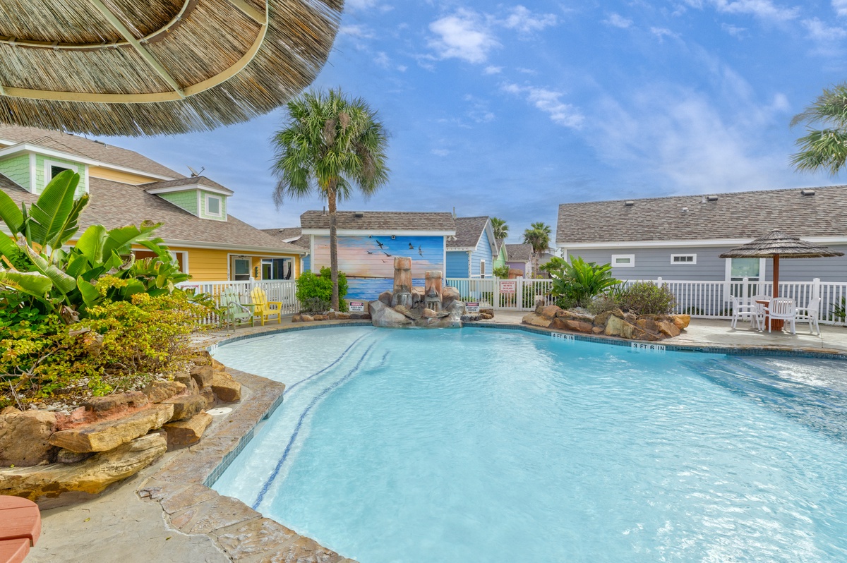 Dive into crystal-clear waters surrounded by tropical palms and colorful beach cottages in this resort-style oasis.