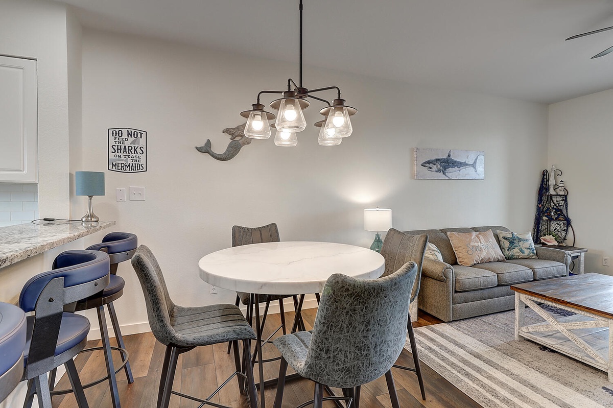 Your stylish open-concept living space blends dining and relaxation with coastal touches and modern comfort.
