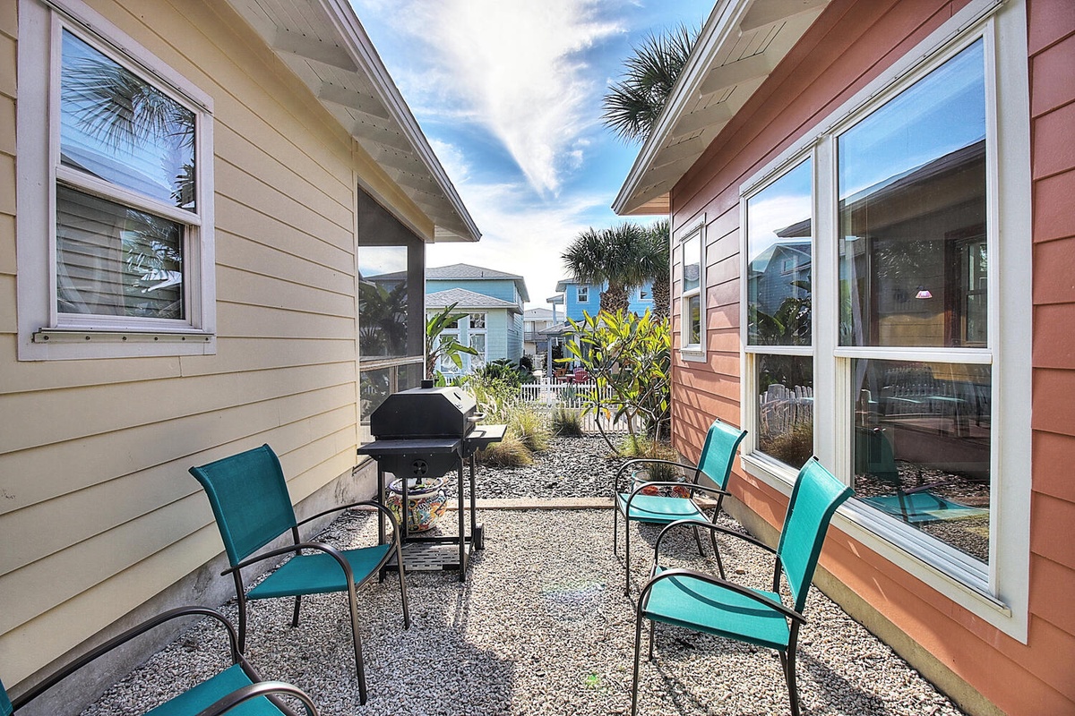 Fire up the grill and gather around turquoise chairs on your private patio, surrounded by colorful beach cottages and swaying palms.
