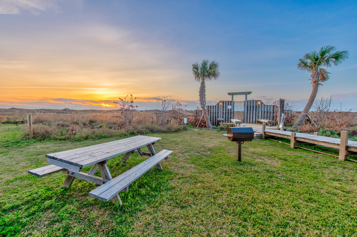 Stunning sunset views paint the sky as evening settles over this oceanfront property with picnic areas and coastal charm.