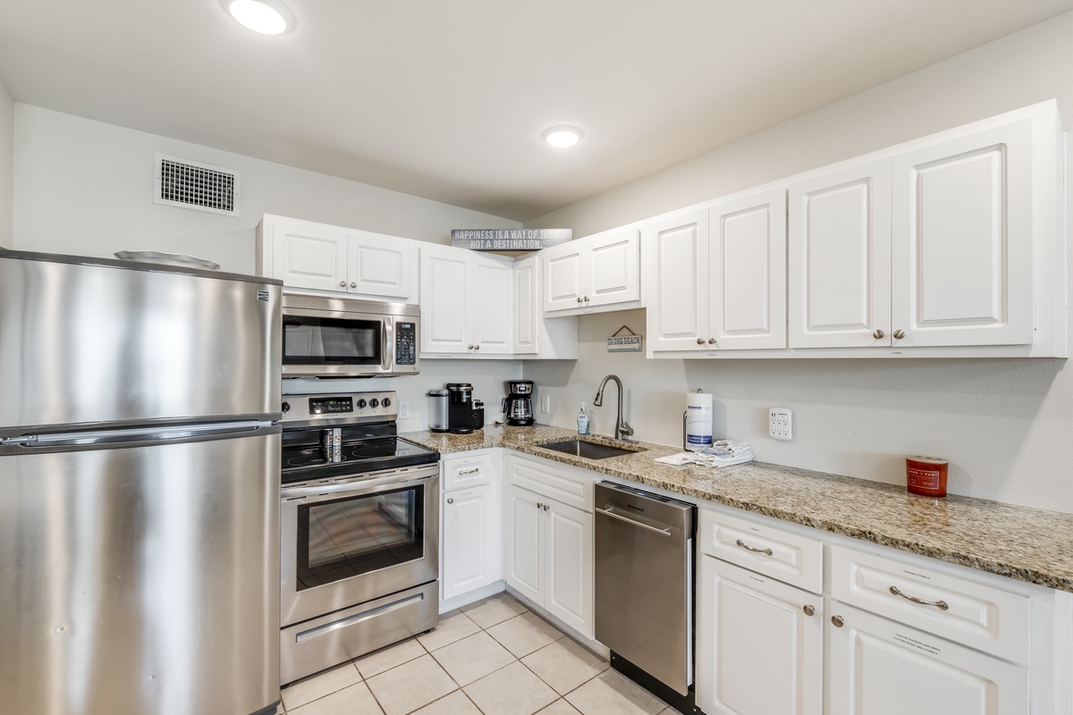 Your fully-equipped kitchen features stainless steel appliances, granite countertops, and crisp white cabinetry perfect for preparing home-cooked meals.