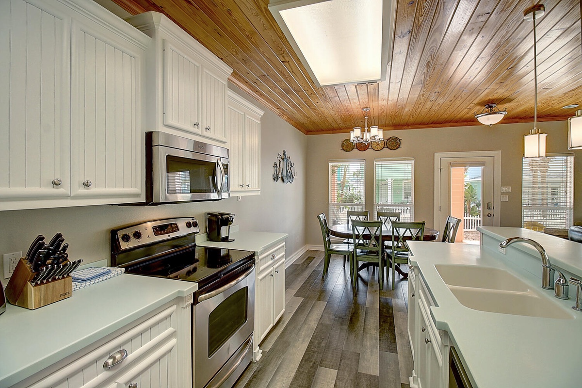 Your fully-equipped kitchen features modern appliances and rustic wood ceilings, perfect for preparing home-cooked meals during your stay.