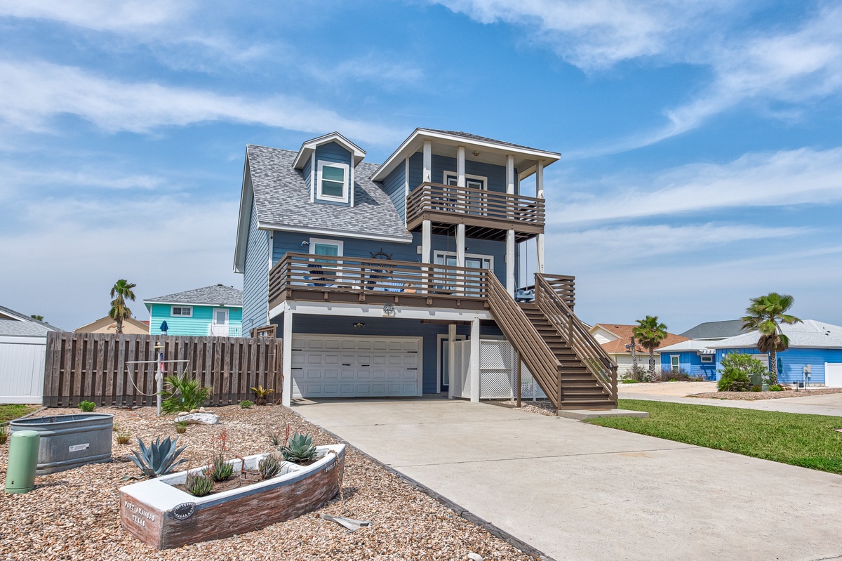 Coastal beach house with elevated design and palm trees in surrounding neighborhood.