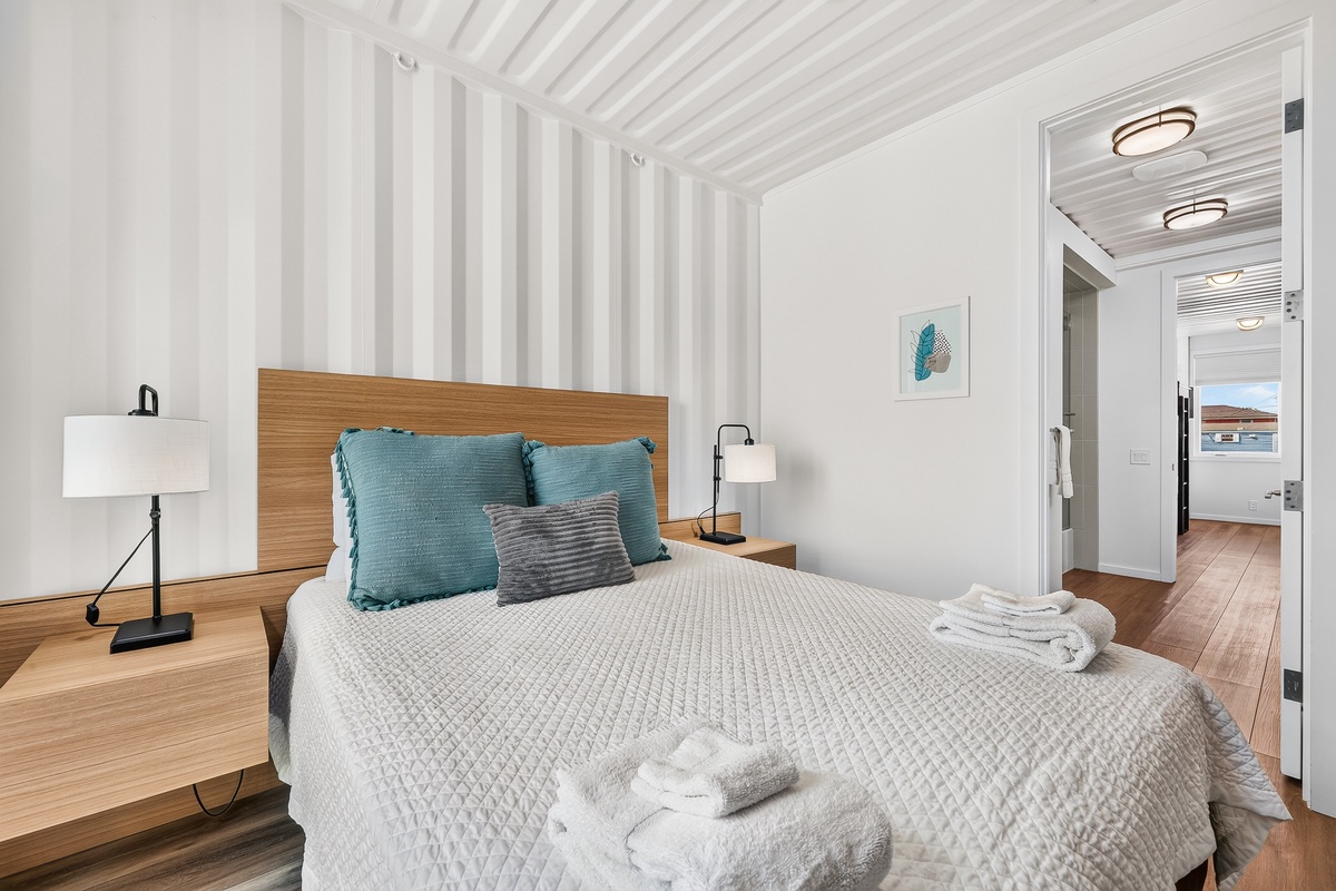 Sink into crisp queen linens and cloud-soft pillows in your second bedroom, where clean lines and coastal-inspired tones create the perfect retreat for restful nights.