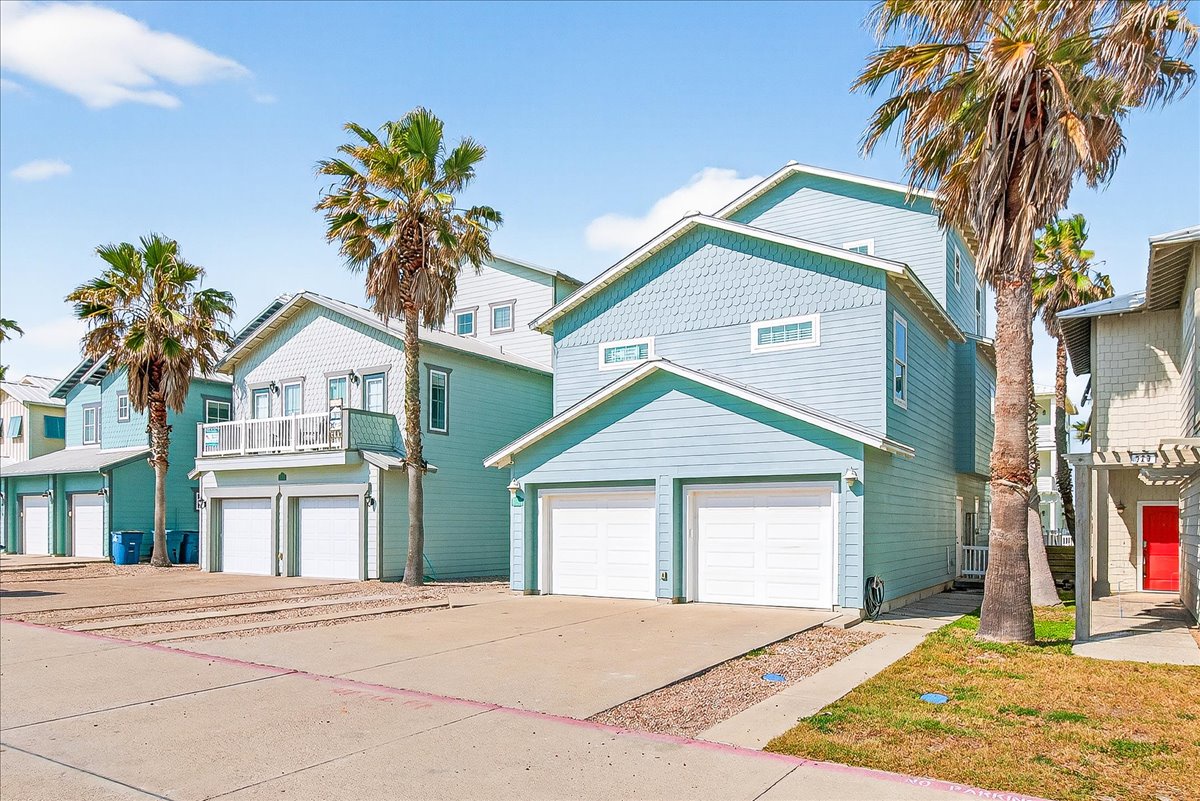 Charming coastal vacation homes line this palm-dotted street, offering beach-house style in a tropical setting.