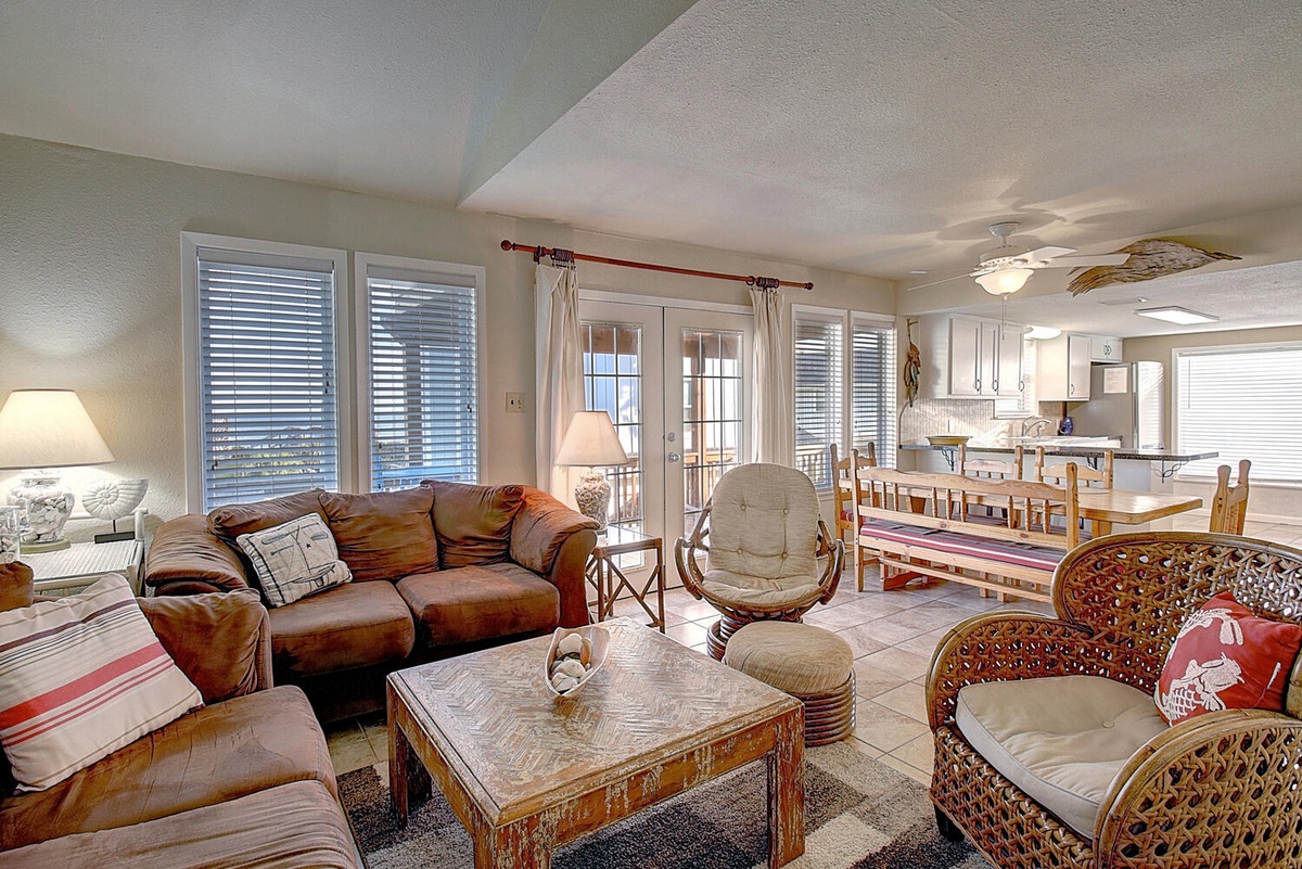 Unwind in your spacious living area where leather sofas and wicker chairs create the perfect coastal retreat for relaxing after beach days.