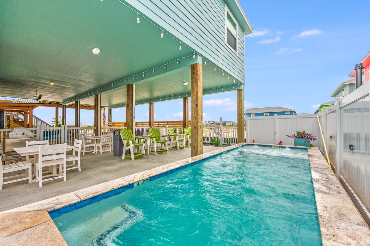 Your private pool paradise awaits, complete with covered patio seating and coastal charm for endless relaxation.