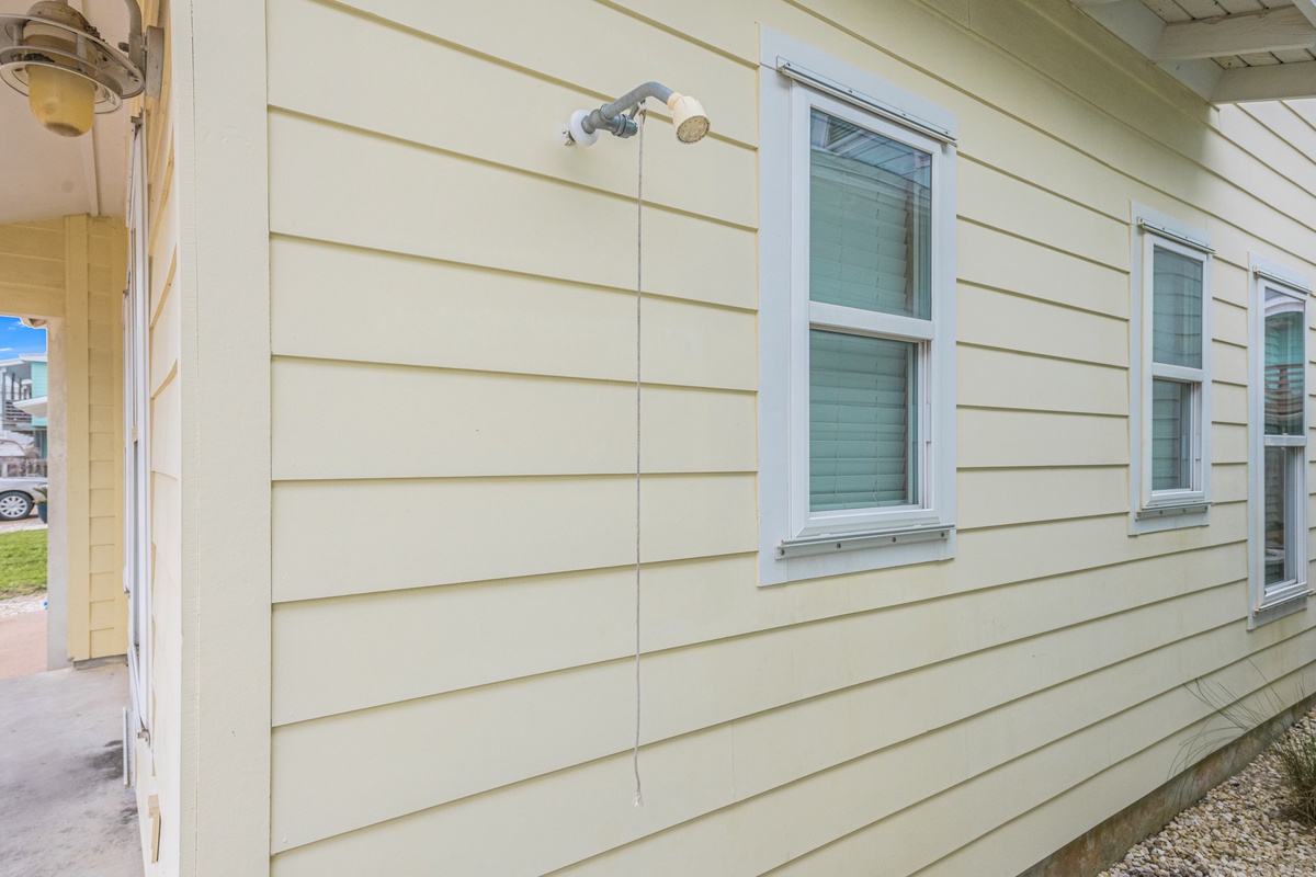 Classic beige siding with white-trimmed windows creates a welcoming exterior for your coastal getaway.