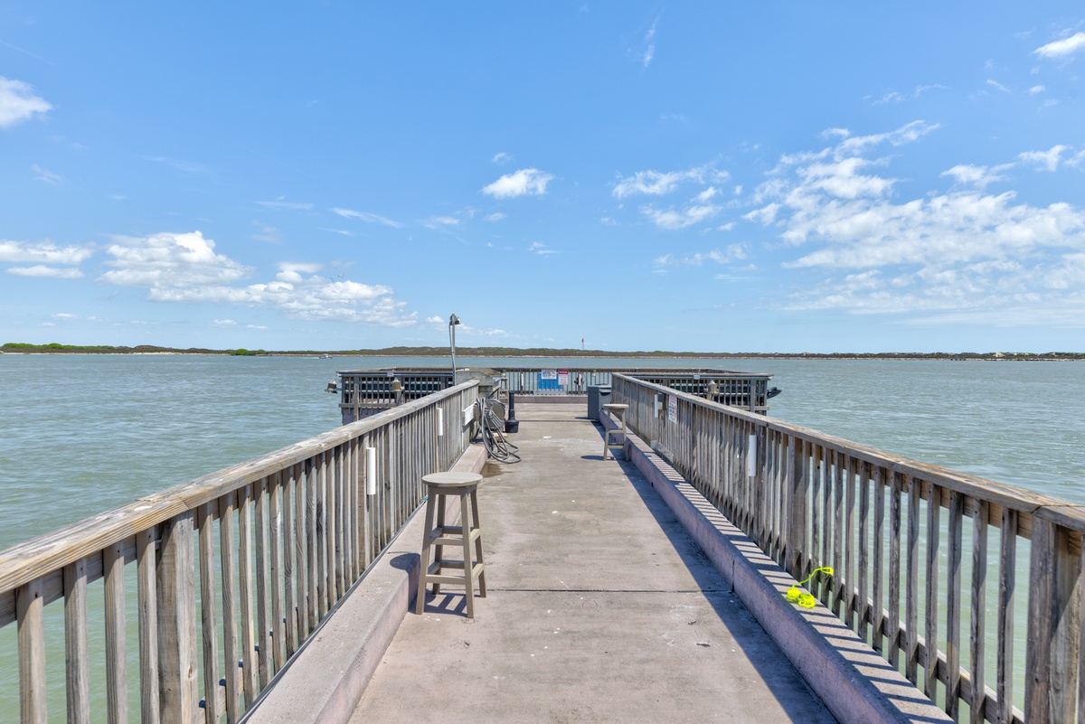 Private fishing pier extends over crystal-clear waters, perfect for casting a line or watching stunning sunsets.