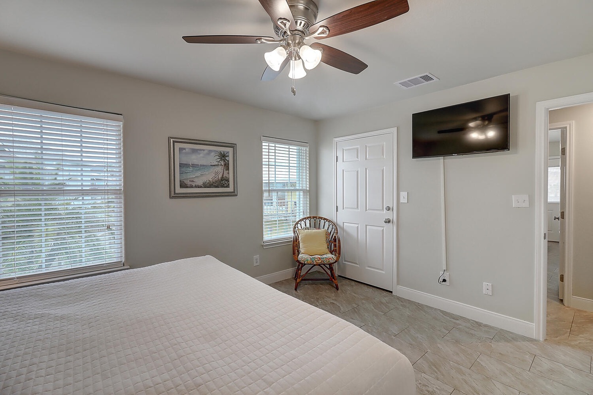 Relax in your peaceful bedroom with soft lighting, charming coastal art, and a cozy reading nook by the window.