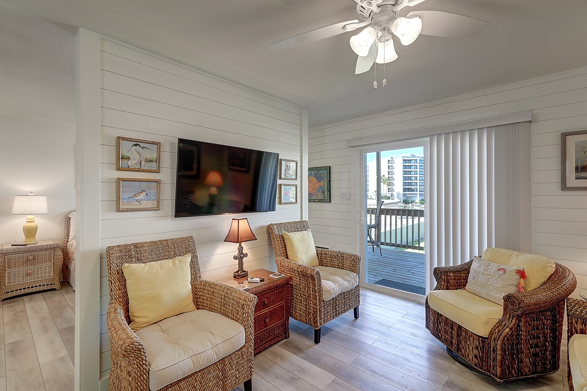 Unwind in this coastal-inspired living room with wicker seating, flat-screen TV, and water views from your private balcony.