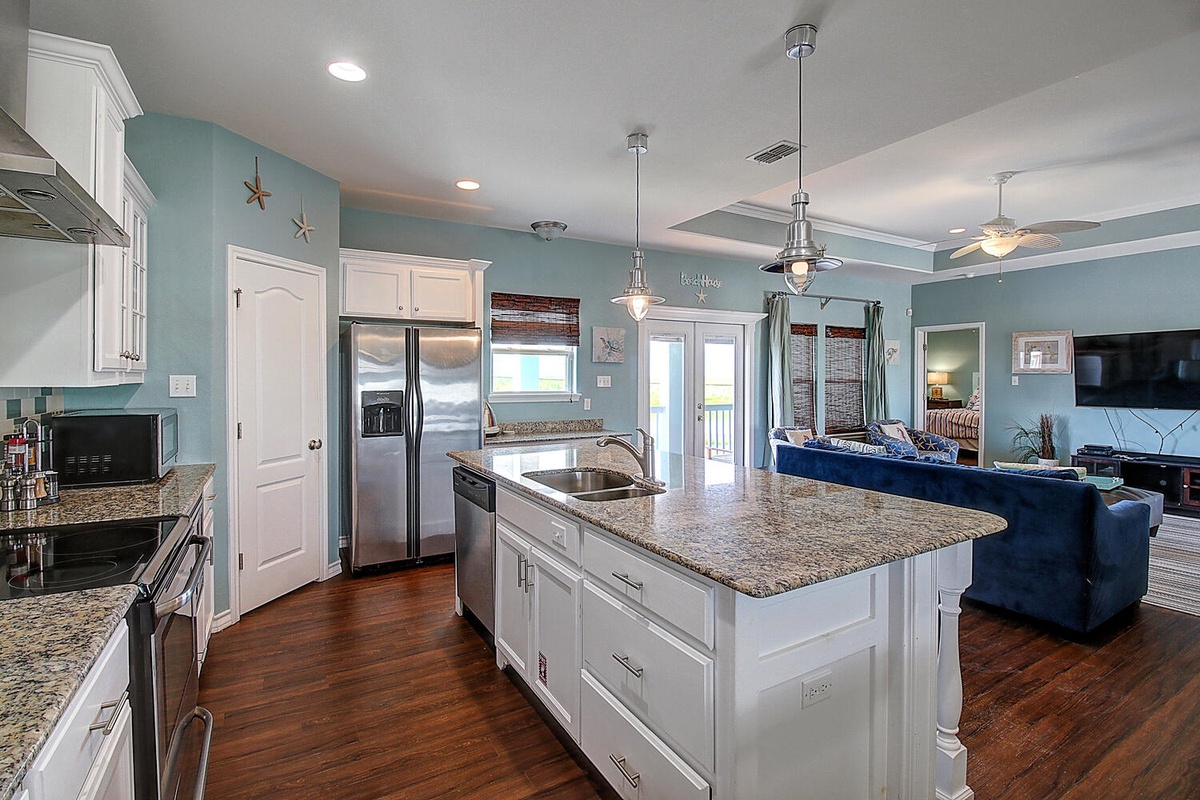 Cook and gather in this stunning open kitchen with granite counters, stainless appliances, and charming coastal blues that flow into your living space.