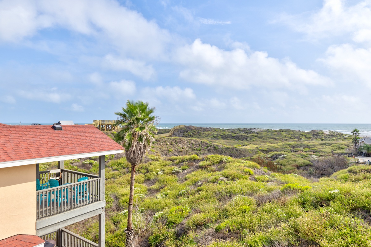 Beautiful coastal property with balcony overlooking pristine natural landscape leading to the ocean.