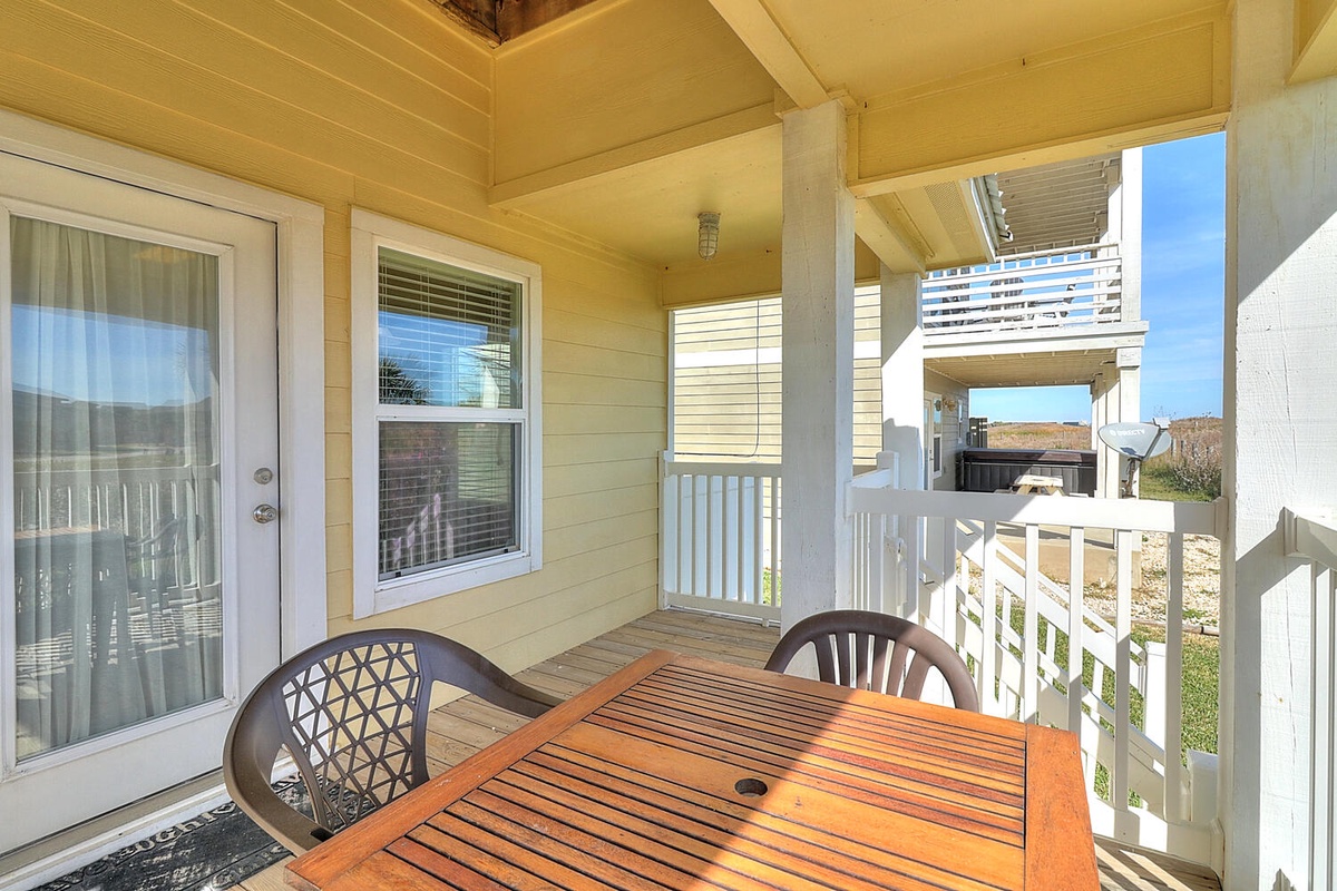 Unwind on your private covered deck with a charming wooden dining table, perfect for morning coffee or al fresco meals.