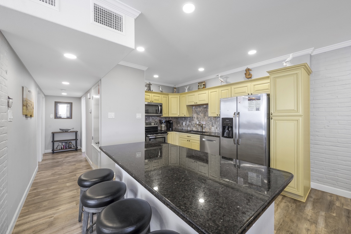 Your fully equipped kitchen features granite countertops, stainless appliances, and a breakfast bar where you can enjoy morning coffee.