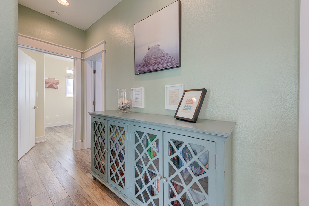 Step into your welcoming hallway featuring a charming storage console and peaceful coastal artwork that sets a relaxing tone for your stay.