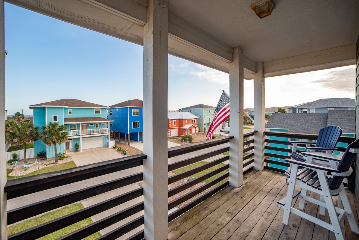 Relax on your private covered balcony with comfortable seating while taking in views of the colorful coastal neighborhood.