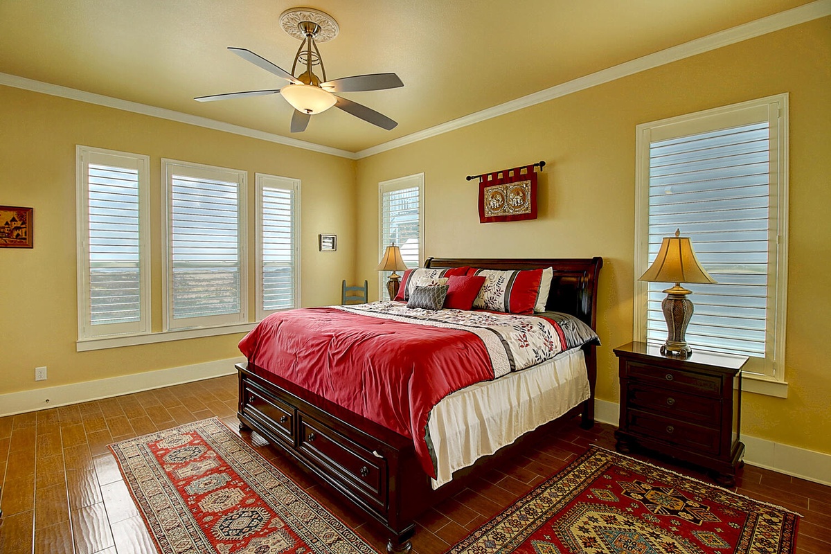Rest in your sunny bedroom where warm golden walls and rich red accents create a cozy retreat with storage-rich hardwood bed.