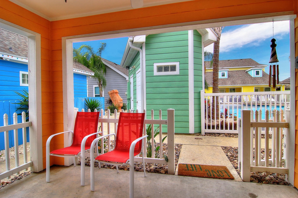 Step onto your private patio and soak in the vibrant beach cottage views. These red chairs are perfect for your morning coffee ritual.