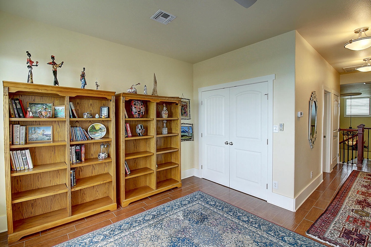 Discover your own private library with warm wood shelves filled with books and collectibles, creating the perfect reading retreat.