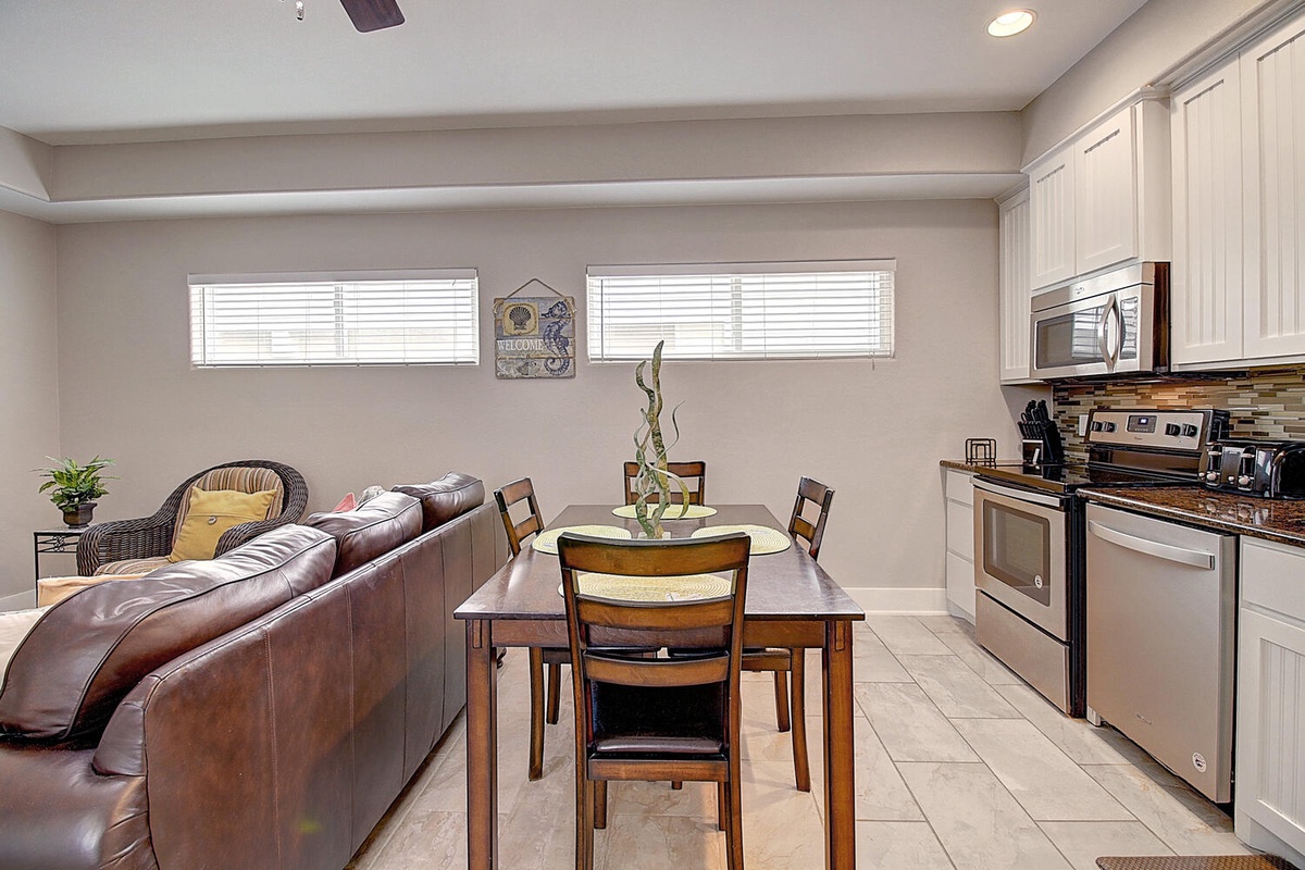 Relax in your open-concept living space where leather seating flows seamlessly into a modern kitchen, perfect for memorable meals together.