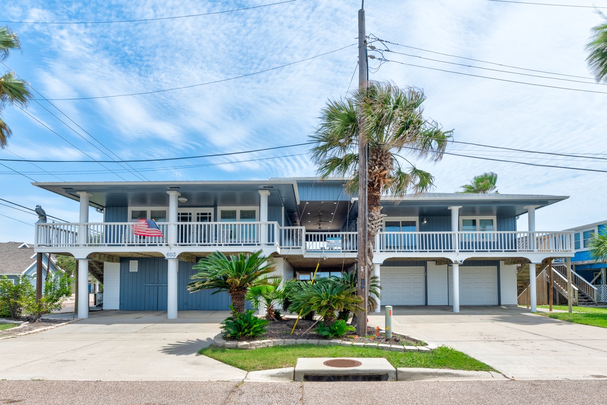 Coastal vacation home with tropical landscaping, parking, and welcoming beach-house architecture in a peaceful residential neighborhood.