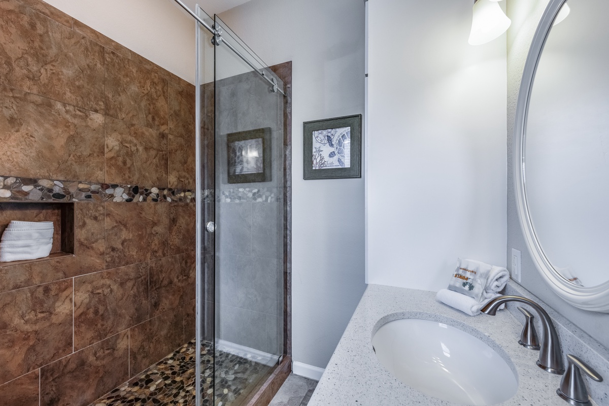 Unwind in your elegant bathroom featuring a luxurious stone-tiled shower and granite vanity, perfectly appointed for your comfort.