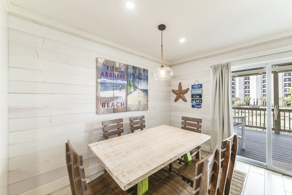 Gather around the warm wood table where your group can share meals and laughter. Coastal charm fills the space with shiplap walls and beachy decor, while sliding doors open to your private balcony.