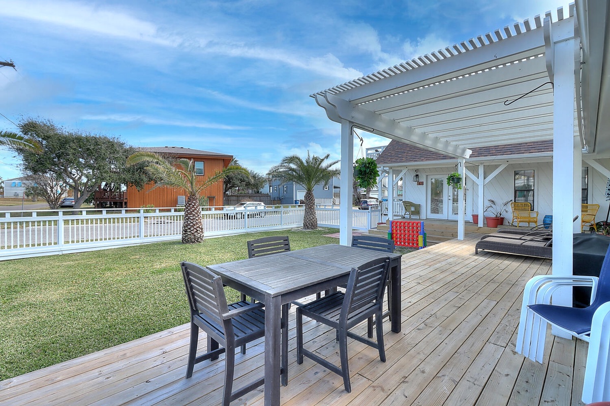 Relax on your spacious covered deck with dining table, overlooking the lush lawn and tropical palms in this peaceful beachside setting.