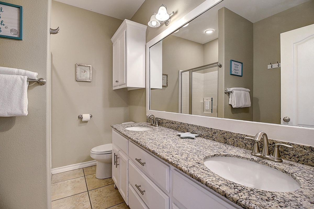 Unwind in your spacious bathroom featuring dual sinks, granite countertops, and thoughtful amenities for a refreshing start to each day.