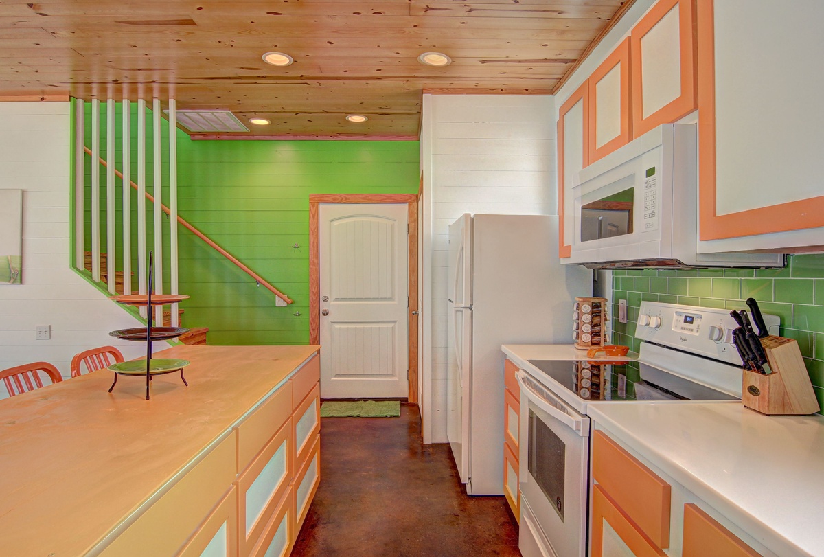 Your vibrant kitchen features modern appliances and colorful tile backsplash, perfect for preparing meals during your stay.