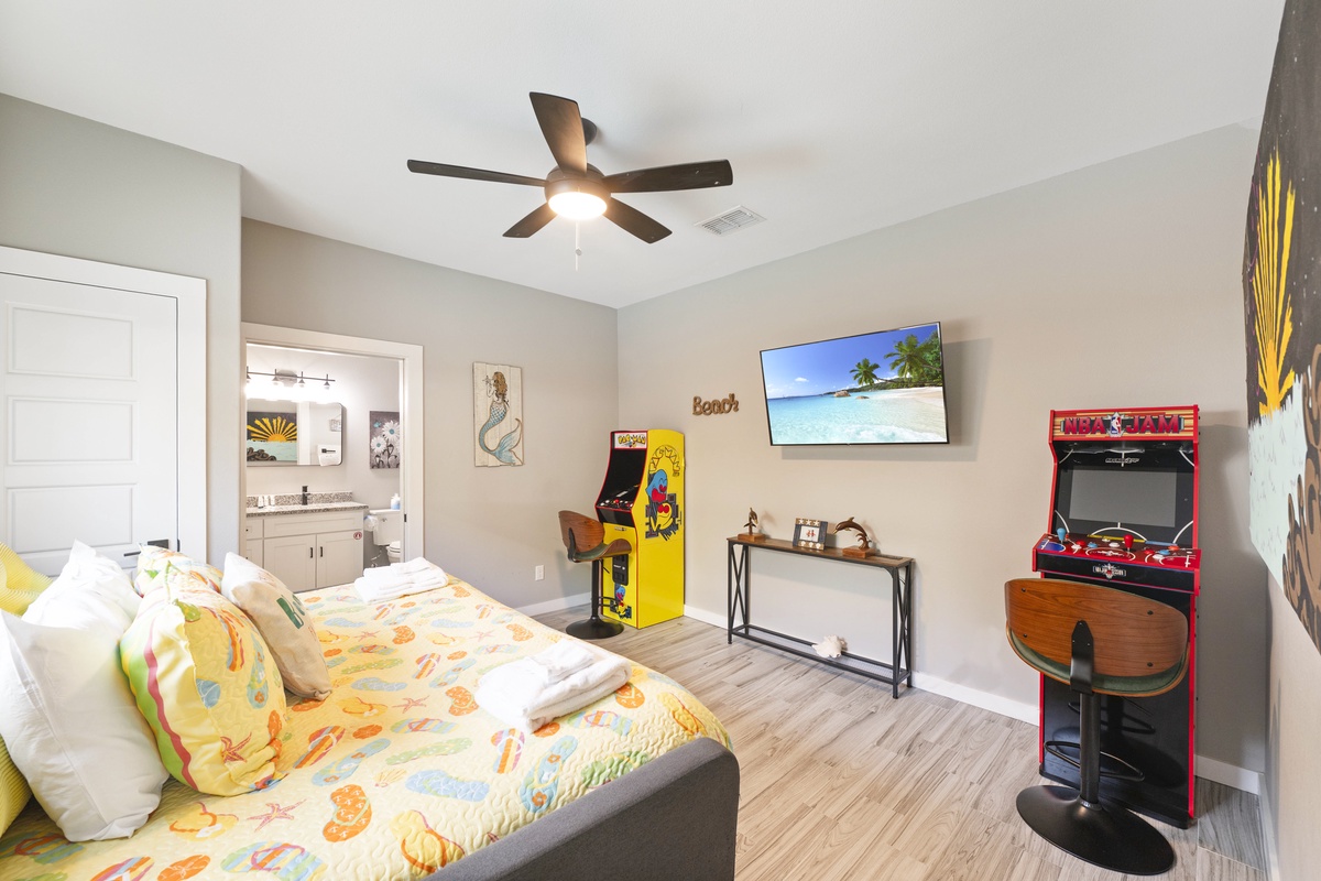 Unwind in your game room featuring retro arcade machines, tropical TV scenes, and cozy seating for endless entertainment.