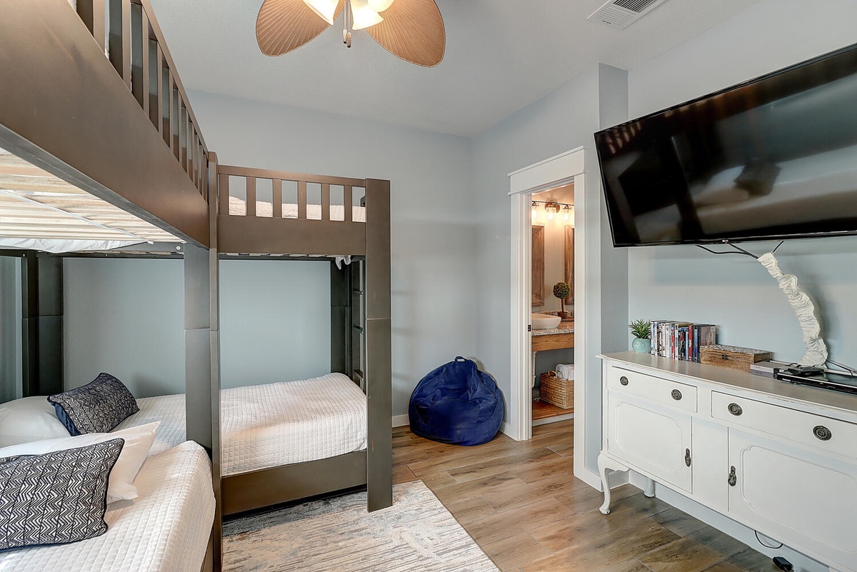 Your kids will love this fun bunk bed setup with a cozy bean bag for lounging and their own TV for movie nights.