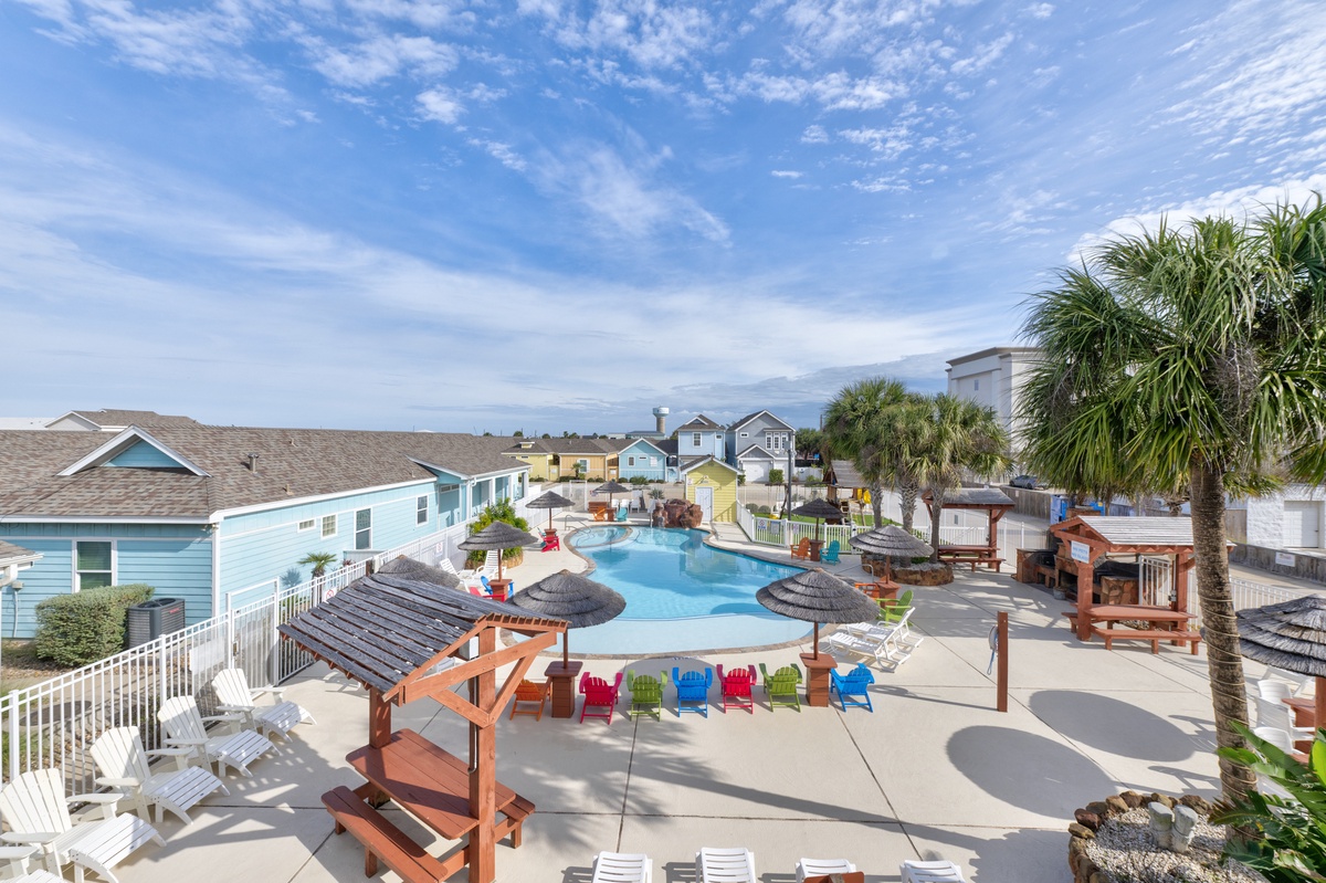 Dive into paradise with this stunning resort pool surrounded by tropical palms and colorful beach chairs.