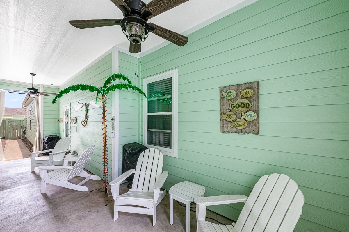 Relax on your private porch with coastal charm—white Adirondack chairs and tropical touches create the perfect spot to unwind.