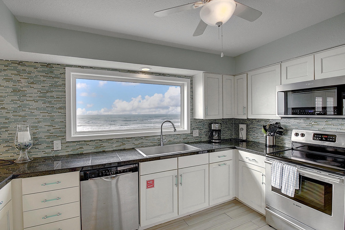 Cook with stunning ocean views through your kitchen window while enjoying modern appliances and elegant tile backsplash.