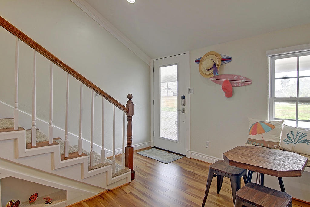 Your bright coastal entryway welcomes you with warm wood floors and charming beach-themed touches, setting a relaxed tone for your getaway.