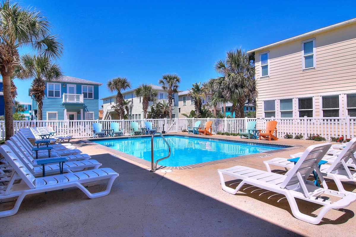 Dive into your private oasis surrounded by colorful beach houses and swaying palms—your perfect poolside retreat awaits.